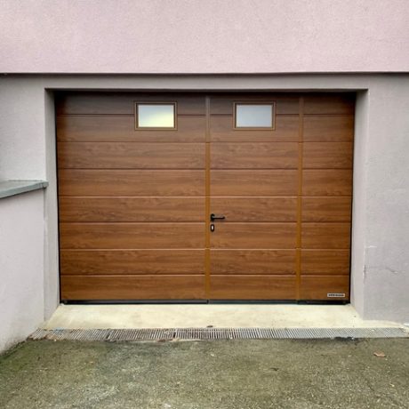 Porte de garage sectionelle avec portillon intégré avec seuil anti trébuchement inox ( 2 aspects l’un en DARK OAK , aspect bois foncé et l’autre en RAL 7016 )