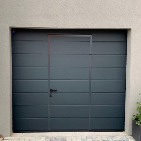 Porte de garage sectionelle avec portillon intégré avec seuil anti trébuchement inox ( 2 aspects l’un en DARK OAK , aspect bois foncé et l’autre en RAL 7016 )